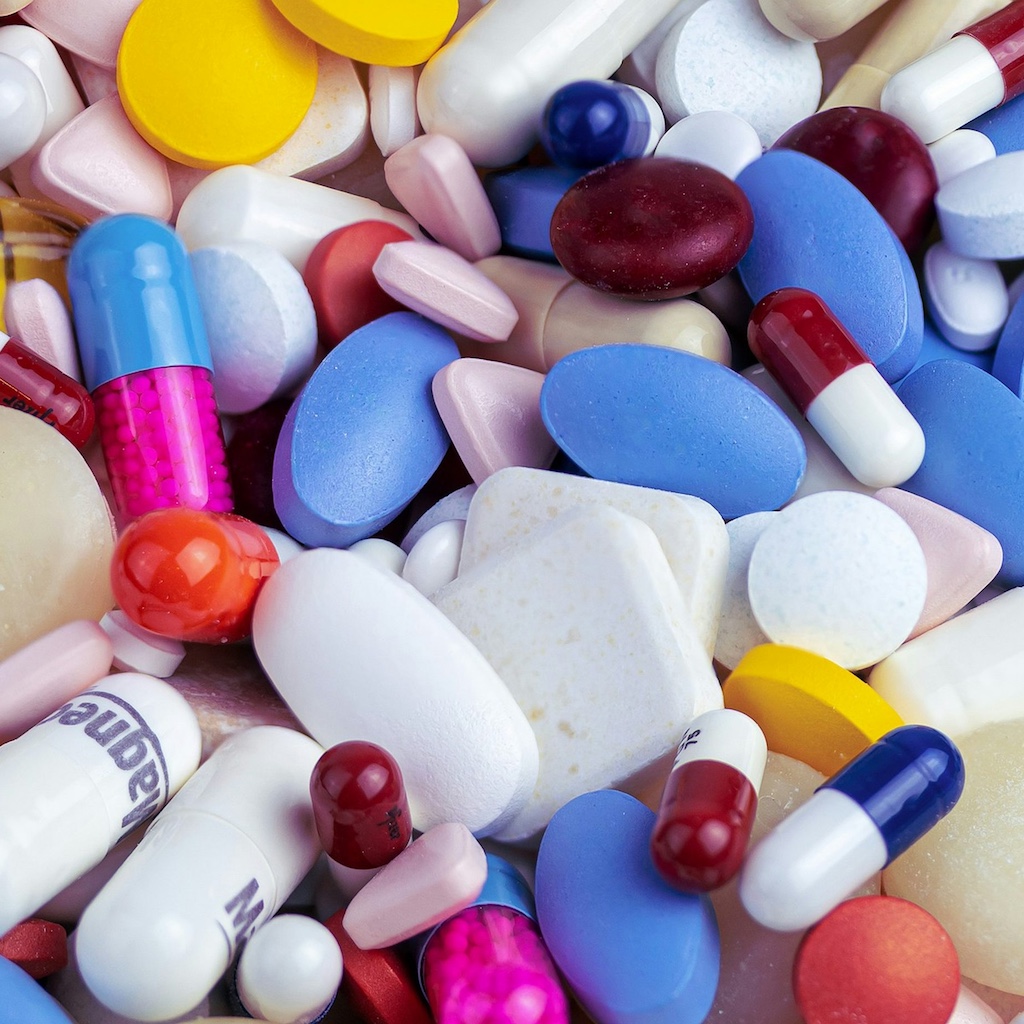 Assorted pharmaceutical tablets and capsules arranged on a clean surface
